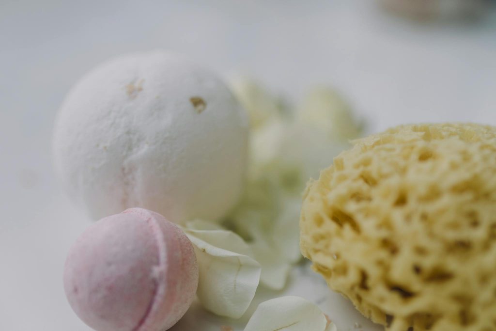 Close-up of spa essentials including bath bombs and a natural sponge for a serene spa experience.