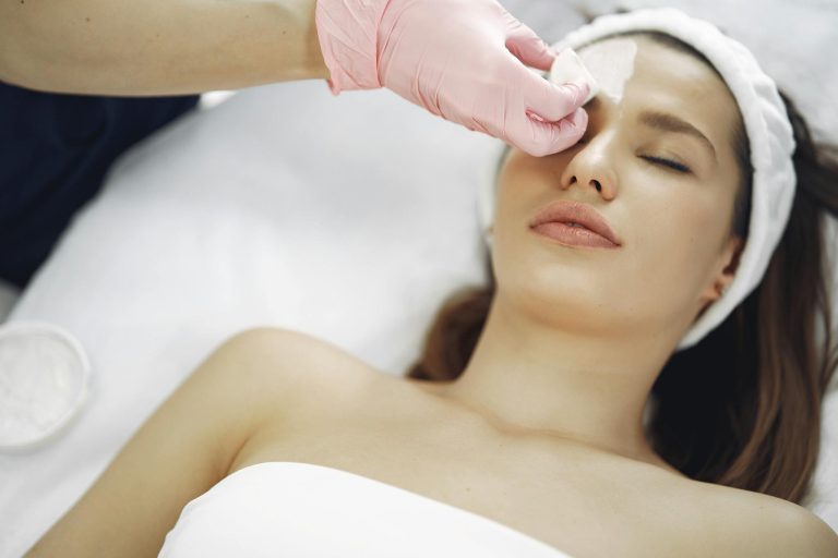 A woman enjoys a soothing facial treatment at a spa, promoting relaxation and skincare.